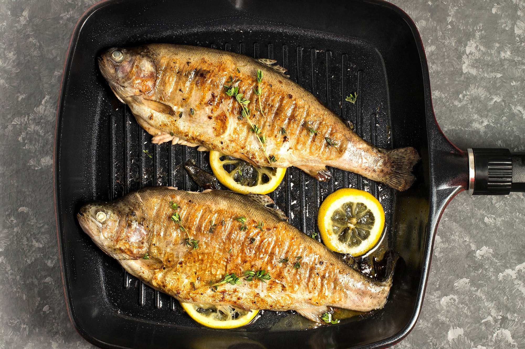 Two trouts cooked on a grill pan